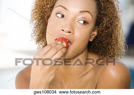 Close-up of a young woman eating a strawberry View Large Photo Image Picture - Close-up of a young woman eating a strawberry. Fotosearch