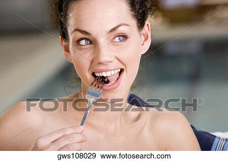 Stock Photo - Close-up of a young woman eating an olive. Fotosearch