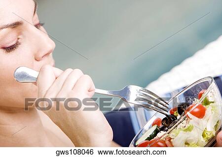 Close-up of a young woman holding a bowl of salad View Large Photo Image Stock Photograph - Close-up of a young woman holding a bowl of salad. Fotosearch