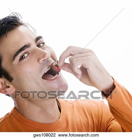 Portrait of a mid adult man eating a chocolate dipped strawberry View Large Photo Image Stock Image - Portrait of a mid adult man eating a chocolate dipped strawberry. Fotosearch