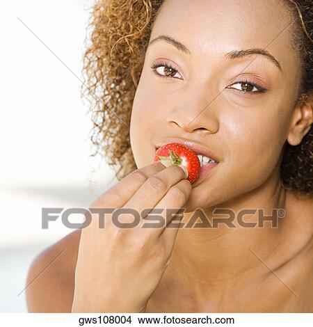 Portrait of a young woman eating a strawberry View Large Photo Image Picture - Portrait of a young woman eating a strawberry. Fotosearch