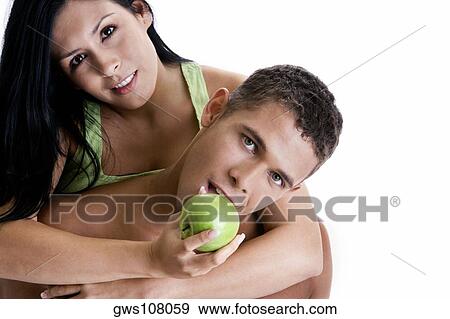 Portrait of a young woman feeding a young man a green apple View Large Photo Image Stock Photo - Portrait of a young woman feeding a young man a green apple. Fotosearch