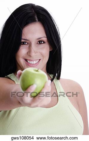 Picture - Portrait of a young woman holding a green apple. Fotosearch