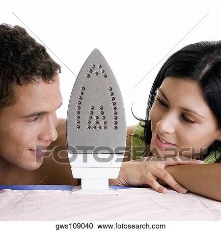 Close-up of a young couple looking at each other with an iron between them View Large Photo Image Stock Image - Close-up of a young couple looking at each other with an iron between them. Fotosearch
