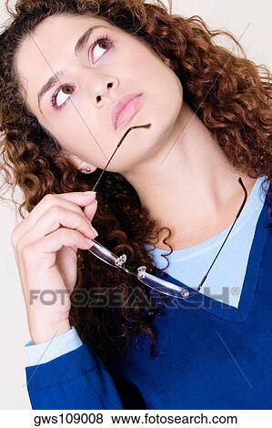 Close-up of a young woman holding her eyeglasses View Large Photo Image Stock Photo - Close-up of a young woman holding her eyeglasses. Fotosearch