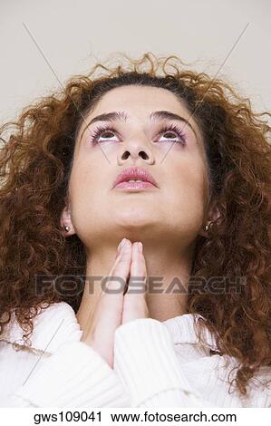 Low angle view of a young woman looking up View Large Photo Image Stock Image - Low angle view of a young woman looking up. Fotosearch