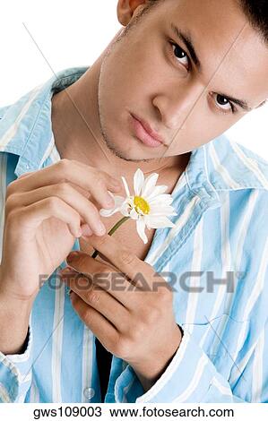 Stock Image - Portrait of a young man plucking petals of a flower. Fotosearch