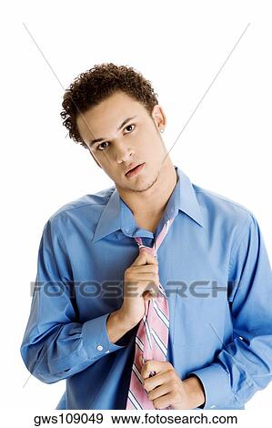 Portrait of a young man pulling his tie View Large Photo Image Stock Photo - Portrait of a young man pulling his tie. Fotosearch