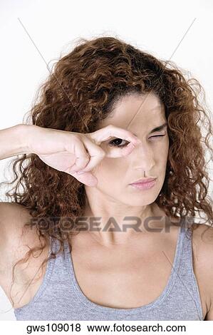Stock Photo - Portrait of a young woman gesturing with her hand. Fotosearch