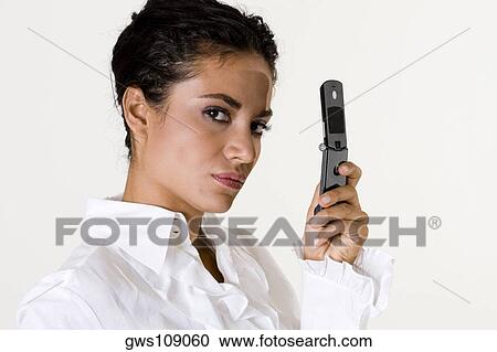 Portrait of a young woman holding a mobile phone View Large Photo Image Stock Image - Portrait of a young woman holding a mobile phone. Fotosearch