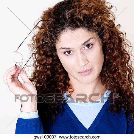 Portrait of a young woman holding her eyeglasses View Large Photo Image Stock Photo - Portrait of a young woman holding her eyeglasses. Fotosearch