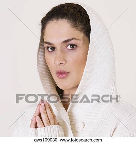 Stock Image - Portrait of a young woman praying. Fotosearch