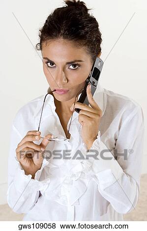 Portrait of a young woman talking on a mobile phone View Large Photo Image Stock Photo - Portrait of a young woman talking on a mobile phone. Fotosearch
