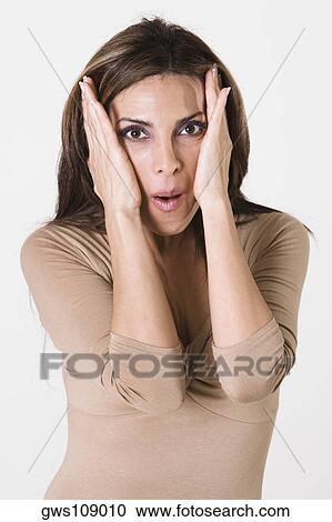 Stock Image - Portrait of a young woman with her hands on her head. Fotosearch