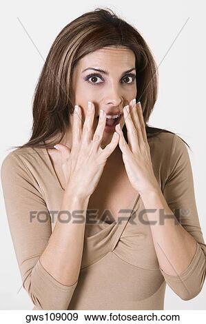 Portrait of a young woman with her hands on her face View Large Photo Image Stock Photo - Portrait of a young woman with her hands on her face. Fotosearch