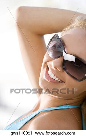 Close-up of a young woman wearing sunglasses View Large Photo Image Stock Image - Close-up of a young woman wearing sunglasses. Fotosearch