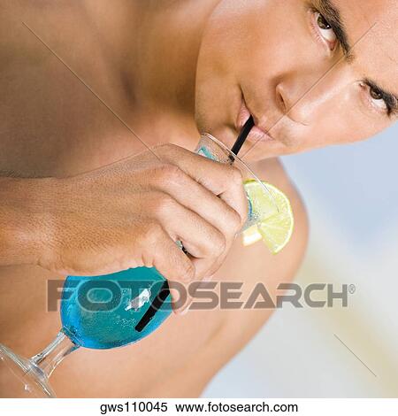 Portrait of a young man drinking a cocktail View Large Photo Image Stock Photography - Portrait of a young man drinking a cocktail. Fotosearch