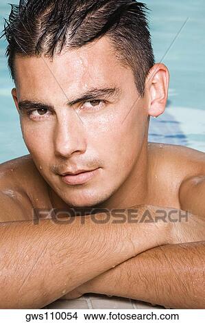 Portrait of a young man leaning at the edge of a swimming pool View Large Photo Image Picture - Portrait of a young man leaning at the edge of a swimming pool. Fotosearch