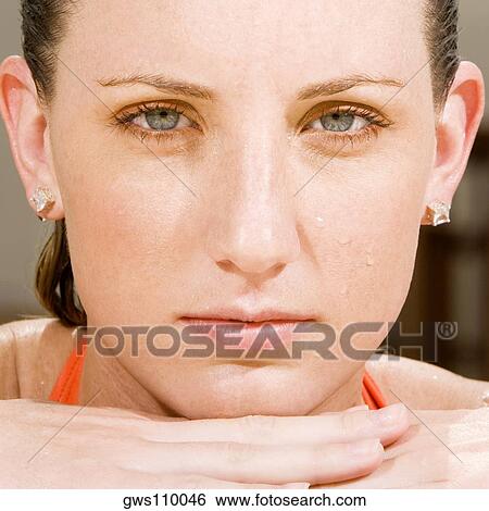 Stock Photograph - Portrait of a young woman with her hand under her chin. Fotosearch