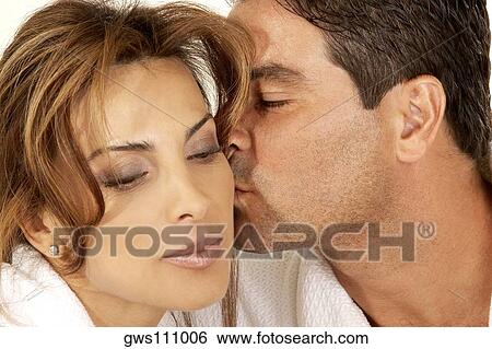 Stock Photograph - Close-up of a mid adult man kissing a mid adult woman on the cheek. Fotosearch
