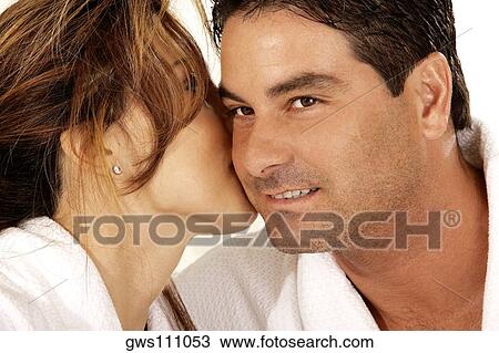 Stock Image - Close-up of a mid adult woman kissing a mid adult man on the cheek. Fotosearch