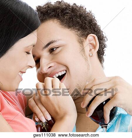 Close-up of a young couple embracing each other View Large Photo Image Stock Photo - Close-up of a young couple embracing each other. Fotosearch