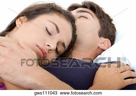 Close-up of a young couple sleeping on a bed View Large Photo Image Stock Image - Close-up of a young couple sleeping on a bed. Fotosearch