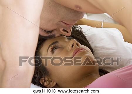 Close-up of a young man lying on top of a young woman in bed View Large Photo Image Stock Image - Close-up of a young man lying on top of a young woman in bed. Fotosearch