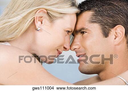 Picture - Close-up of a young woman and a mid adult man looking at each other. Fotosearch