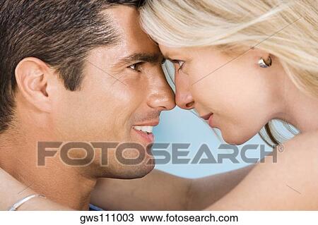 Close-up of a young woman and a mid adult man looking at each other View Large Photo Image Stock Image - Close-up of a young woman and a mid adult man looking at each other. Fotosearch