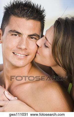 Stock Image - Close-up of a young woman kissing a young man. Fotosearch