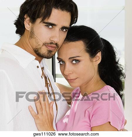 Portrait of a young couple embracing each other View Large Photo Image Stock Photograph - Portrait of a young couple embracing each other. Fotosearch
