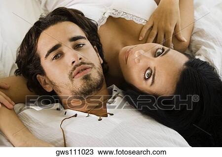 Portrait of a young couple lying on the bed View Large Photo Image Stock Image - Portrait of a young couple lying on the bed. Fotosearch