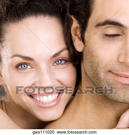 Stock Image - Portrait of a young woman and a mid adult man smiling. Fotosearch