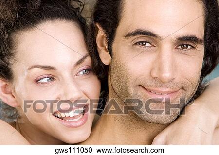 Stock Image - Portrait of a young woman and a mid adult man smiling. Fotosearch