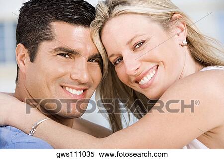 Stock Photography - Portrait of a young woman and a mid adult man smiling. Fotosearch