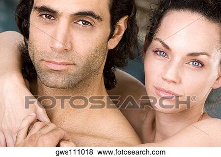 Stock Photo - Portrait of a young woman embracing a mid adult man from behind. Fotosearch