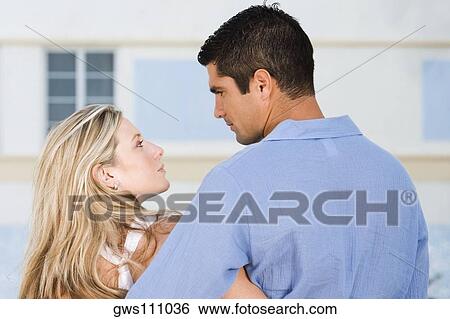 Rear view of a young woman and a mid adult man looking at each other View Large Photo Image Stock Photograph - Rear view of a young woman and a mid adult man looking at each other. Fotosearch