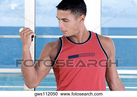 Close-up of a young man squeezing a hand grip View Large Photo Image Stock Image - Close-up of a young man squeezing a hand grip. Fotosearch