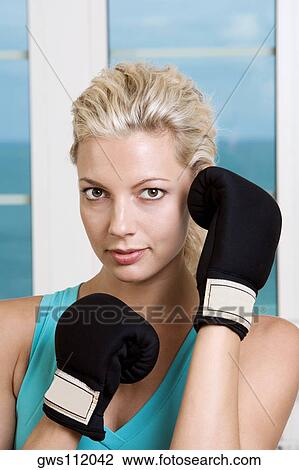 Close-up of a young woman wearing boxing gloves View Large Photo Image Stock Image - Close-up of a young woman wearing boxing gloves. Fotosearch