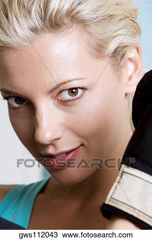 Close-up of a young woman wearing boxing gloves View Large Photo Image Stock Image - Close-up of a young woman wearing boxing gloves. Fotosearch