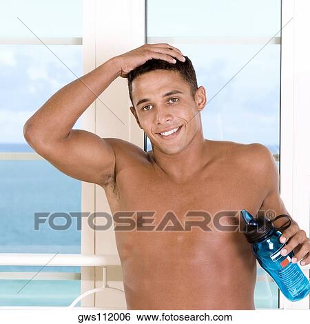Stock Photograph - Portrait of a young man holding a bottle of water. Fotosearch