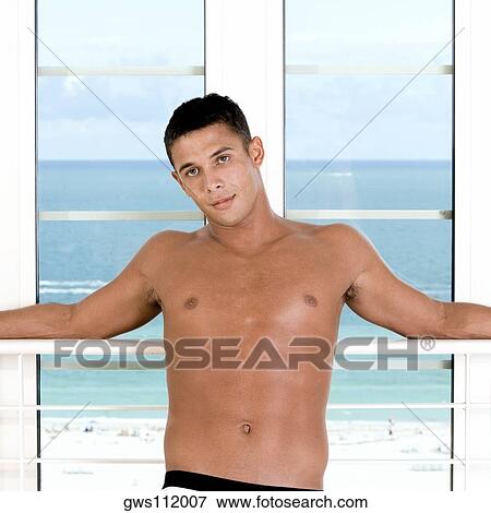 Portrait of a young man leaning against a window View Large Photo Image Stock Photo - Portrait of a young man leaning against a window. Fotosearch