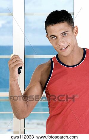 Portrait of a young man squeezing a hand grip View Large Photo Image Stock Image - Portrait of a young man squeezing a hand grip. Fotosearch