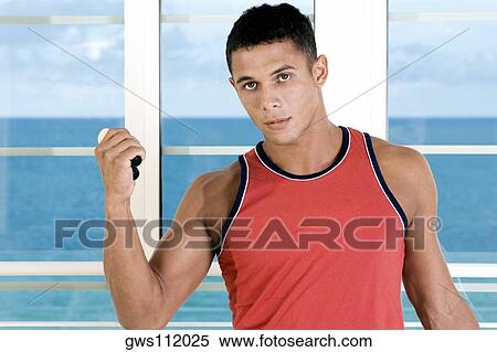 Portrait of a young man squeezing a hand grip View Large Photo Image Stock Photography - Portrait of a young man squeezing a hand grip. Fotosearch