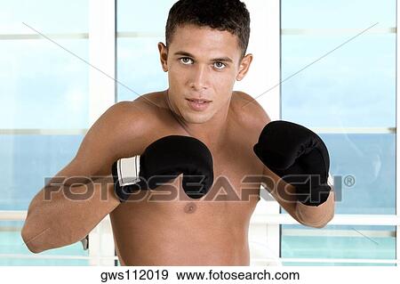 Portrait of a young man wearing boxing gloves View Large Photo Image Stock Photo - Portrait of a young man wearing boxing gloves. Fotosearch