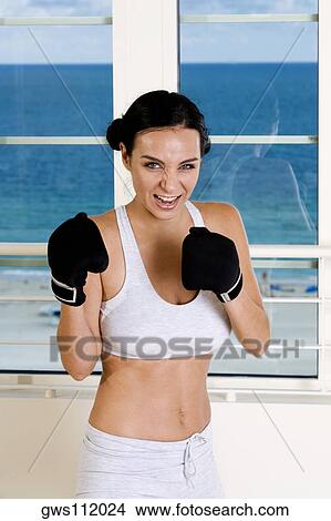 Portrait of a young woman wearing boxing gloves View Large Photo Image Picture - Portrait of a young woman wearing boxing gloves. Fotosearch