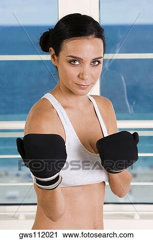 Portrait of a young woman wearing boxing gloves View Large Photo Image Stock Image - Portrait of a young woman wearing boxing gloves. Fotosearch