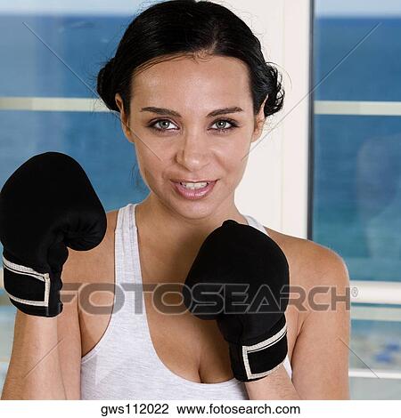 Portrait of a young woman wearing boxing gloves View Large Photo Image Stock Image - Portrait of a young woman wearing boxing gloves. Fotosearch