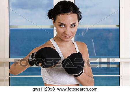 Portrait of a young woman wearing boxing gloves View Large Photo Image Stock Photo - Portrait of a young woman wearing boxing gloves. Fotosearch